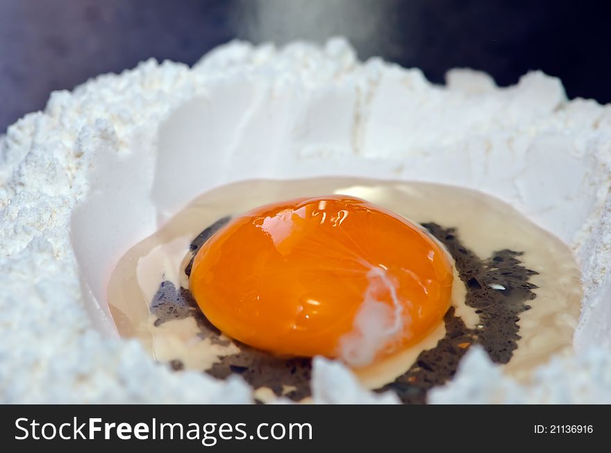 A photo of en egg broken into flour. A photo of en egg broken into flour