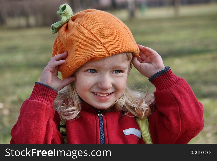 Little girl adjusts his hat during a walk