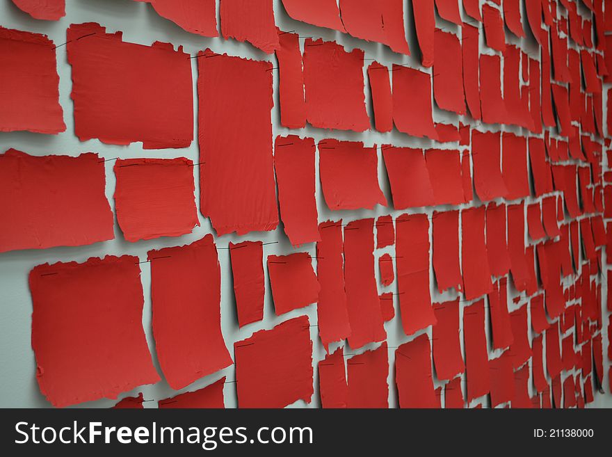 Lot of red sheets on a white wall. Lot of red sheets on a white wall