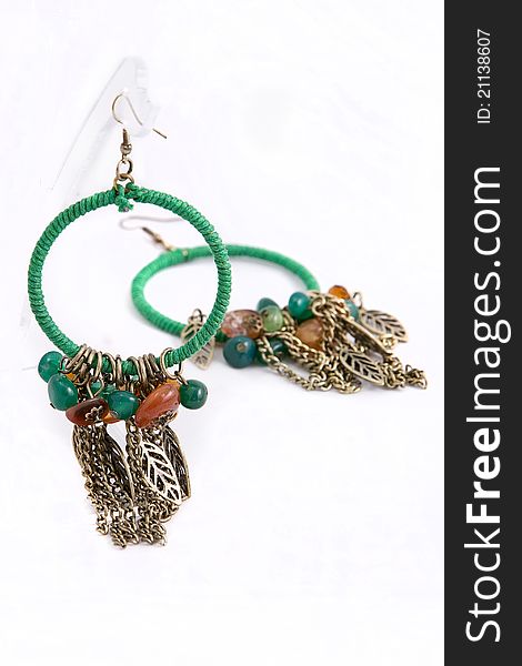 A pair of green earrings hanging on a web. A pair of green earrings hanging on a web