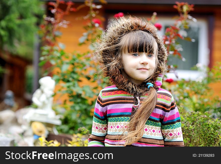 Outdoors portrait of adorable child girl in hood