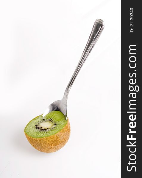 Spoon scooping kiwi on white background. Spoon scooping kiwi on white background