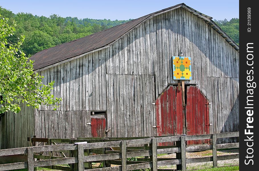 A barn with a quilt square over the door. A barn with a quilt square over the door