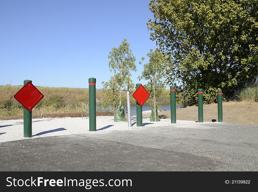 A row of green posts that mark the very end of a road. A row of green posts that mark the very end of a road