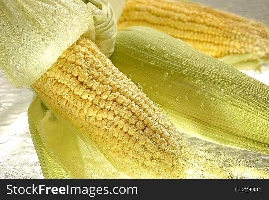 Sweet corn with green leaves and drops. Sweet corn with green leaves and drops