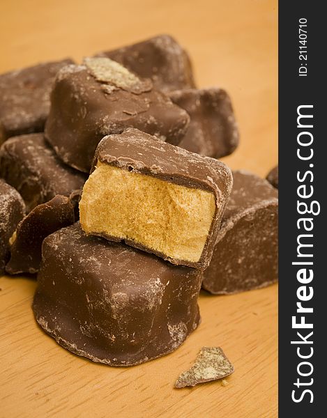 Pieces of chcoclate honeycomb on a table. Pieces of chcoclate honeycomb on a table