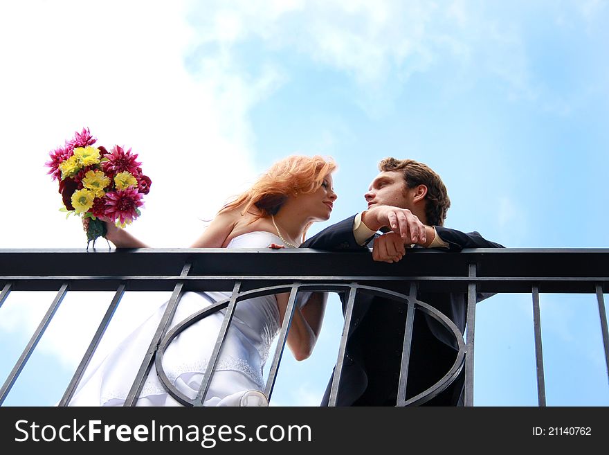 A bride and groom on a balcony. A bride and groom on a balcony