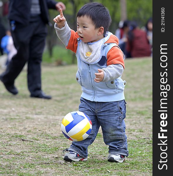 A cute baby is playing football. A cute baby is playing football