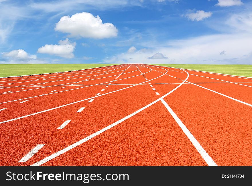 red running track with sky and clouds