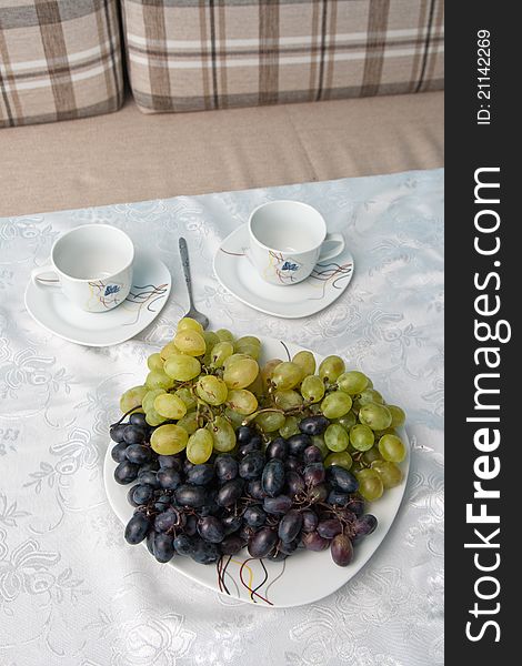 Grapes and two cups on the table