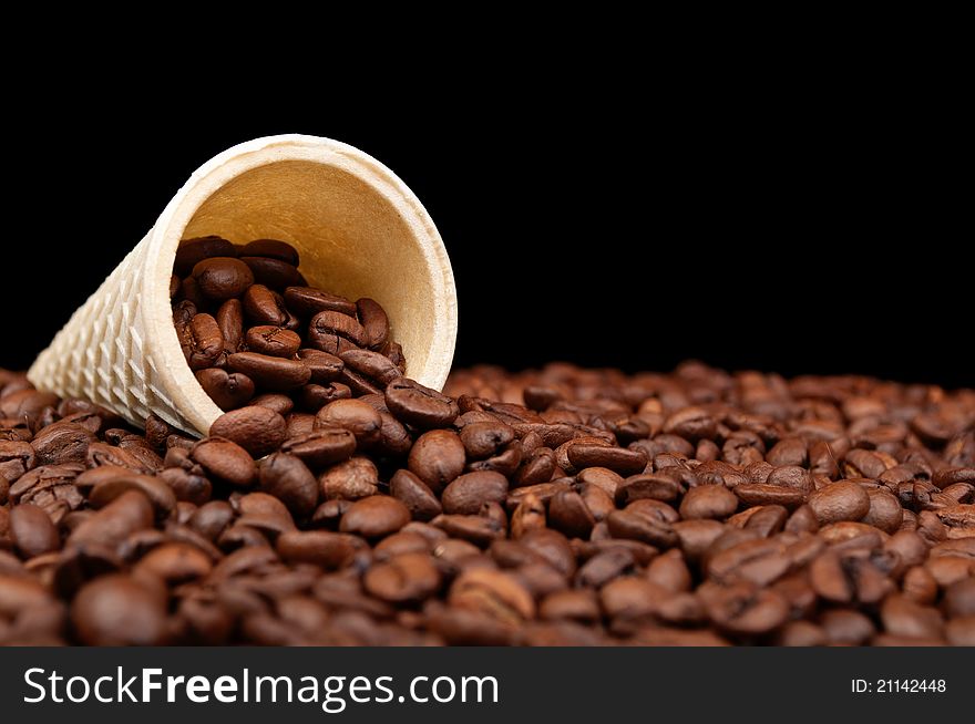 Cone and roasted coffee beans on a black background