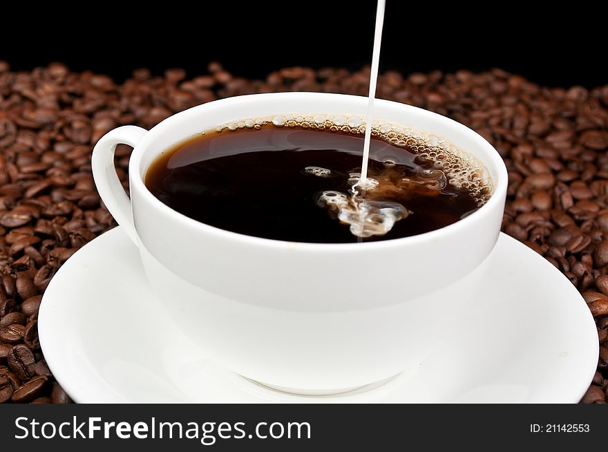 Coffee with milk and coffee beans on a black background