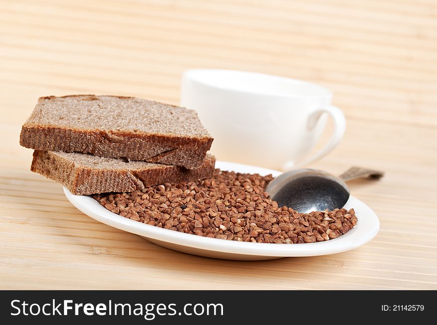 Buckwheat and rye bread on plate on a wooden background