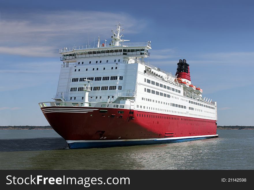 Red and white passenger ship not far from coastline. Red and white passenger ship not far from coastline.