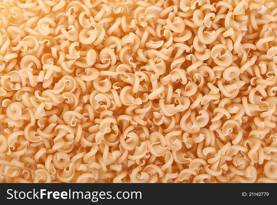 Raw and spiral pasta on a background