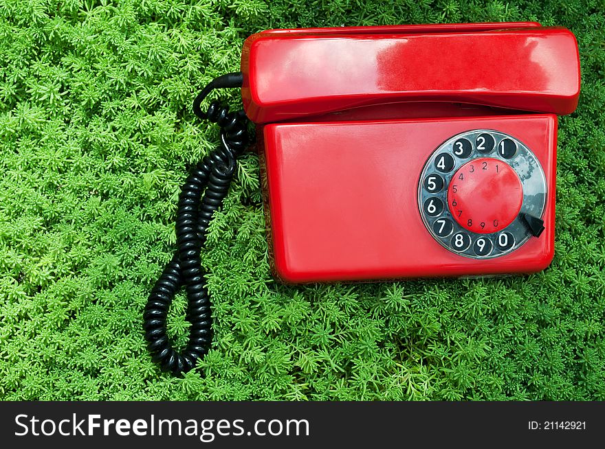 Retro telephone on a green grass background. Retro telephone on a green grass background
