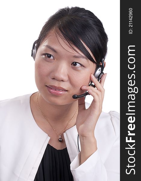 Young asian receptionist talking on hands free headset to customer isolated. Young asian receptionist talking on hands free headset to customer isolated