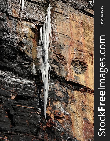 Dripping frozen icicles on a cliff face