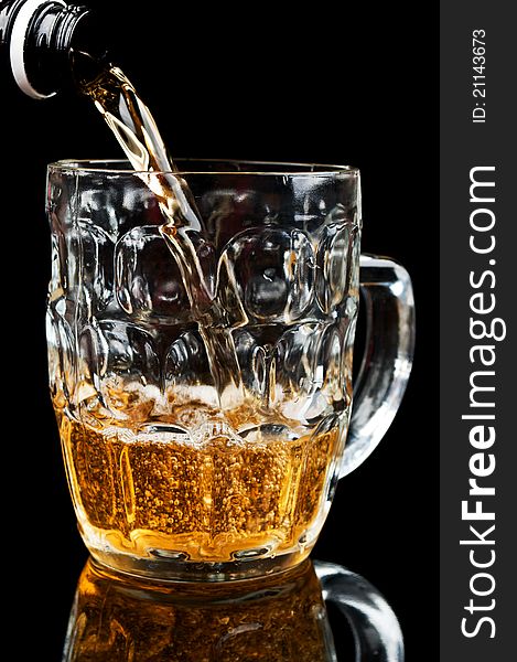 Fresh glass of beer isolated on a black background