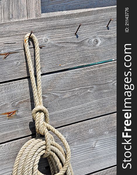 Rope hanging on a wall of old wood.