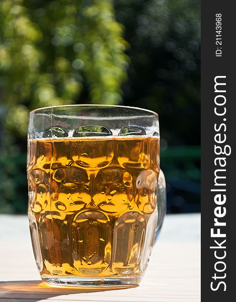 Fresh glass of beer on a wooden table