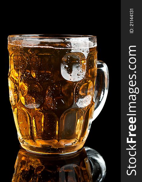 Fresh glass of beer isolated on a black background