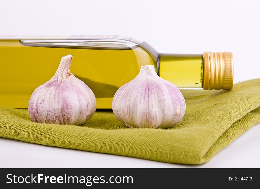 Olive oil and fresh garlic on green texture