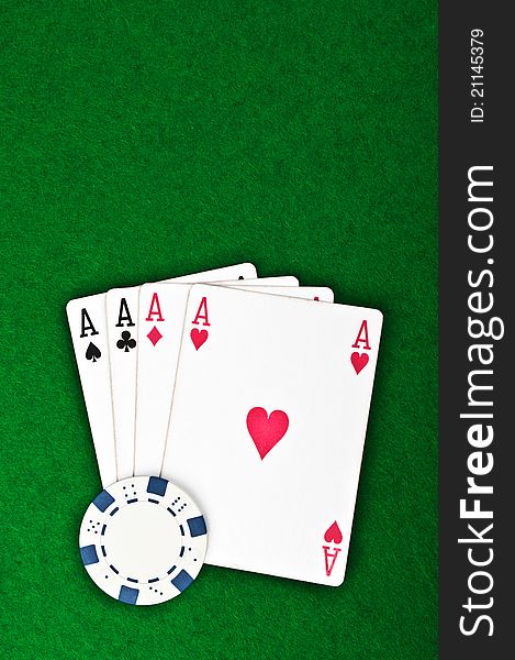 Four aces and poker chips on a green felt