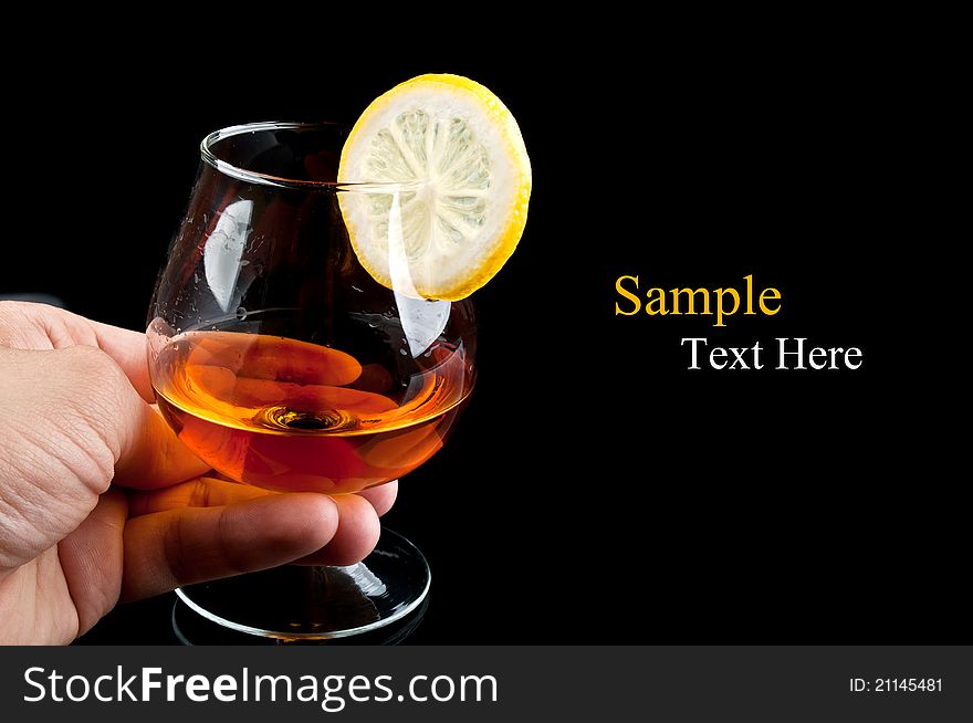 Cognac with lemon in hand