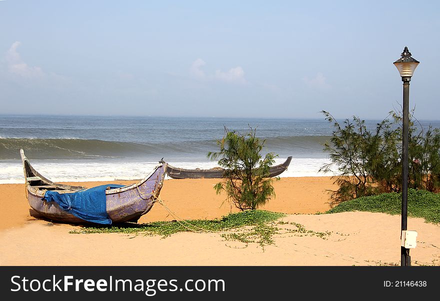 Two country fishing boats resting at a beach in Kerala