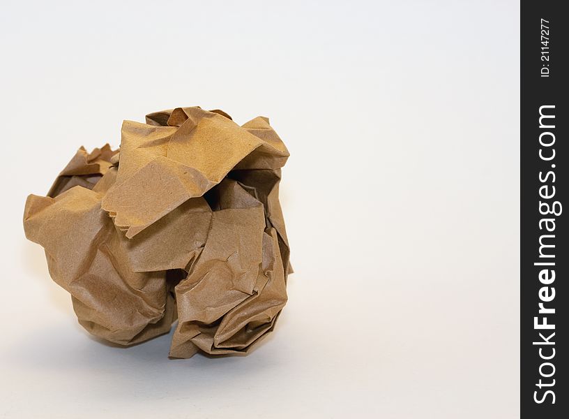 A crumpled piece of brown wrapping paper on a white background with copyspace. A crumpled piece of brown wrapping paper on a white background with copyspace.