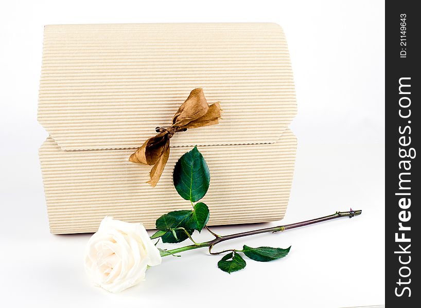 Studio shot of White Gift Box with Gold Bow And White Rose on white background