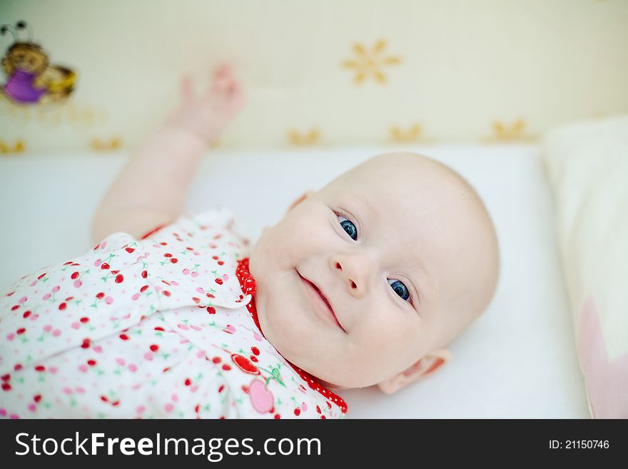 Little beautiful baby girl lying in her bed and smiling. Little beautiful baby girl lying in her bed and smiling