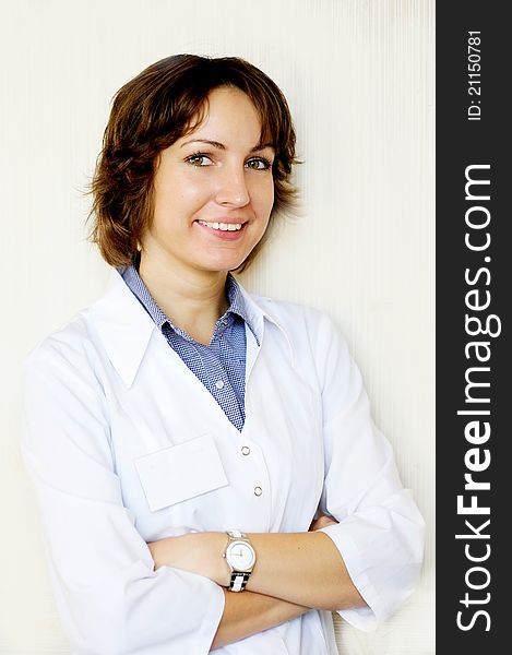 Portrait of a smiling female doctor against a white wall. Portrait of a smiling female doctor against a white wall