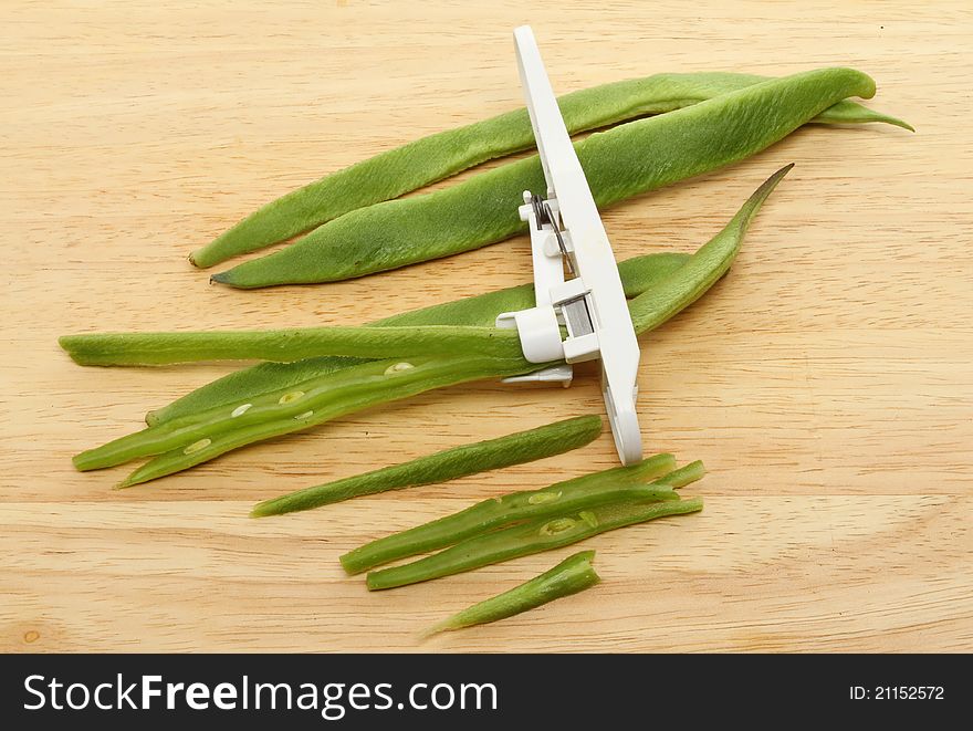 Runner beans and cutting tool on a wooden board. Runner beans and cutting tool on a wooden board