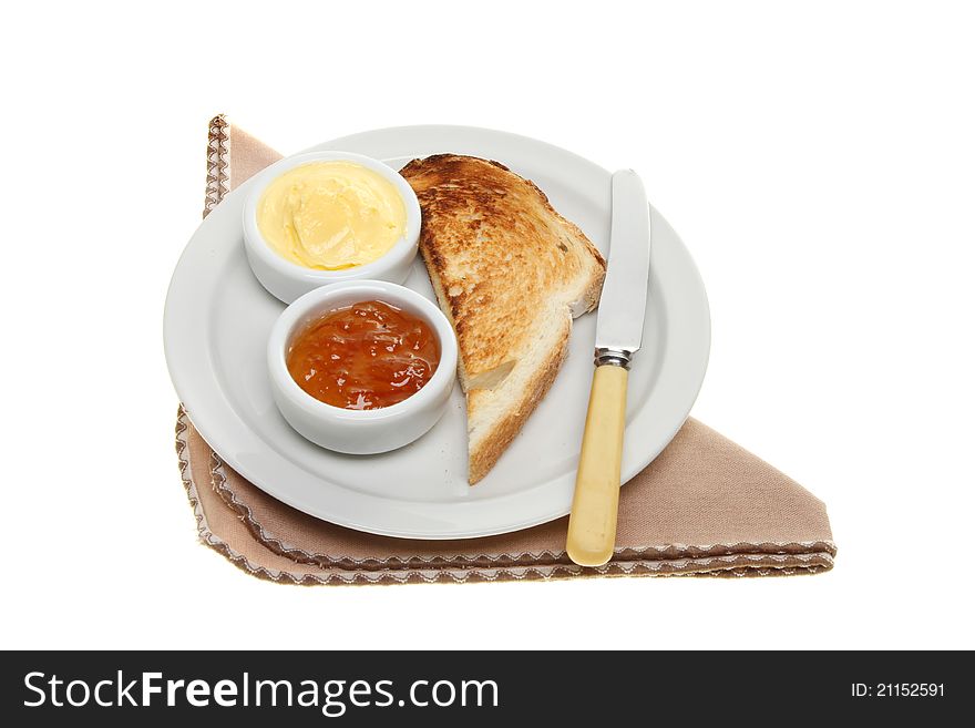 Toast, butter and marmalade on a plate with a knife and napkin isolated against white. Toast, butter and marmalade on a plate with a knife and napkin isolated against white