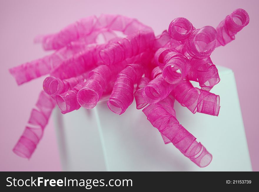 A white gift box with a bright fuchsia bow. A white gift box with a bright fuchsia bow