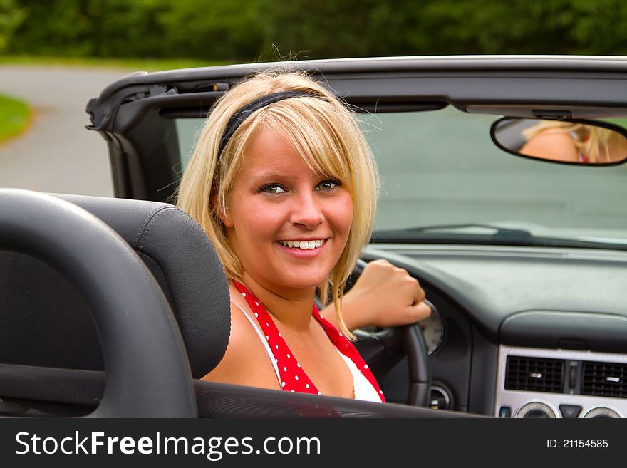 Beautiful woman driver  in open top convertible.