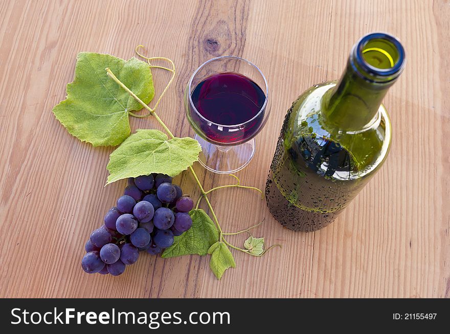 Bunch of grapes with a glass of wine and bottle