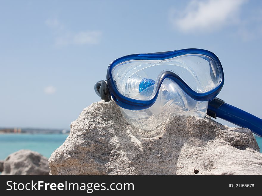 Diving goggles on a rock infront of the sea. Diving goggles on a rock infront of the sea