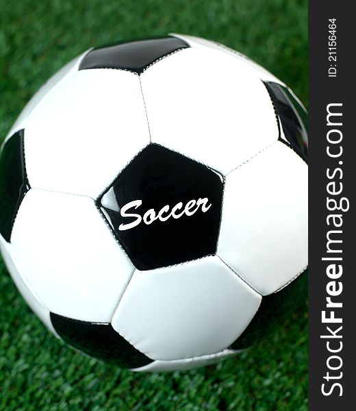 Black and white soccer balls on artificial grass