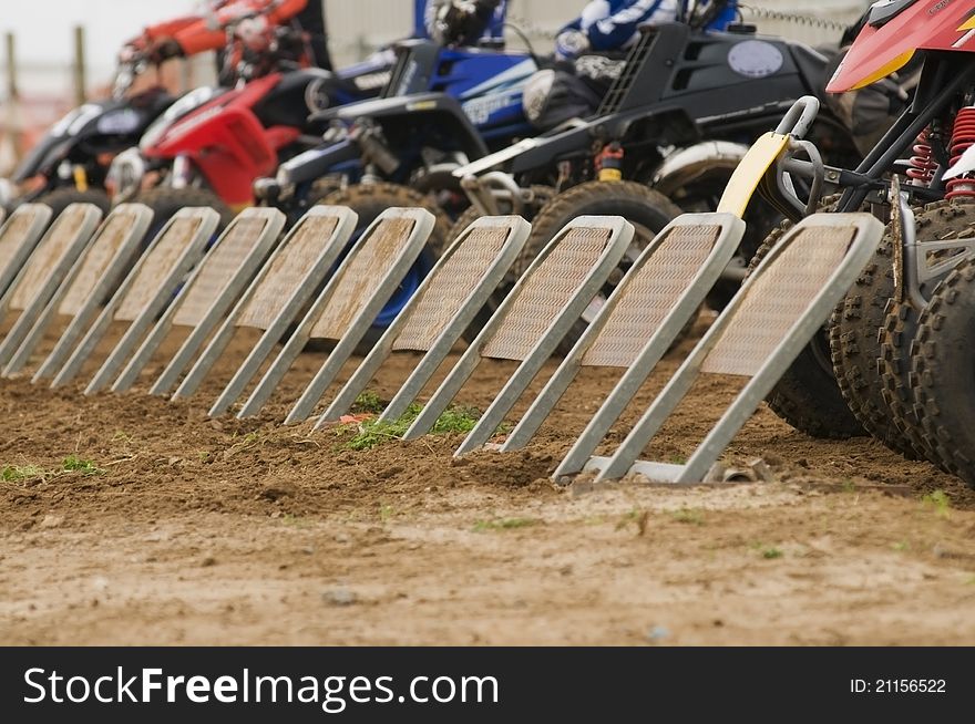 Quad bike racing on dirt track going around a corner with wheels airborne