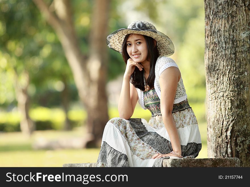 Young smiling asian woman relaxed sitting outdoor. Young smiling asian woman relaxed sitting outdoor