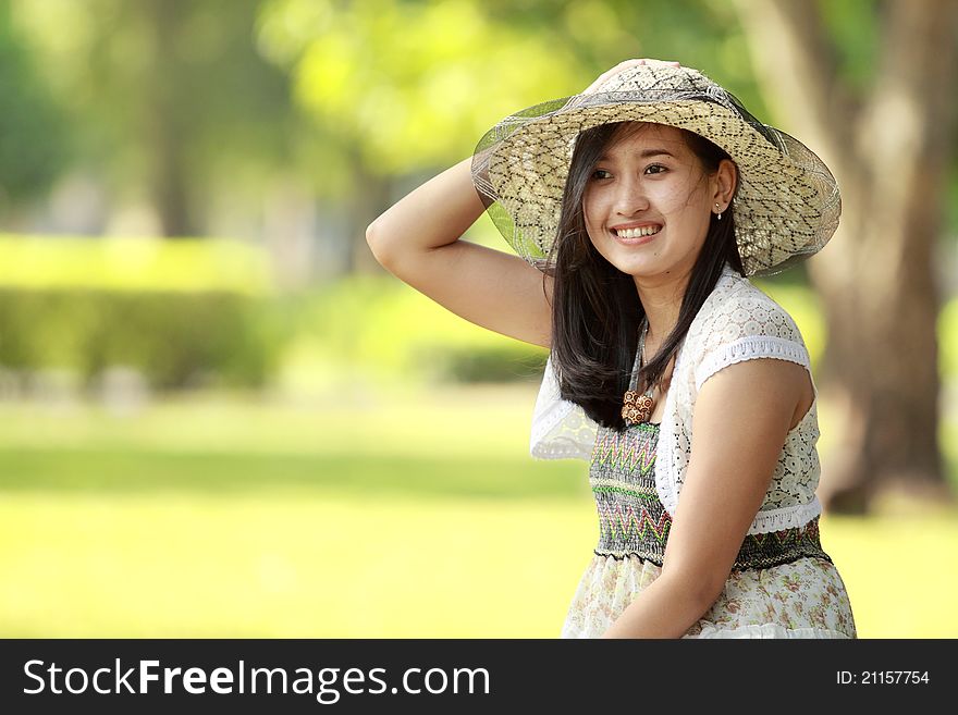 Portait of asian young woman smiling in a green park