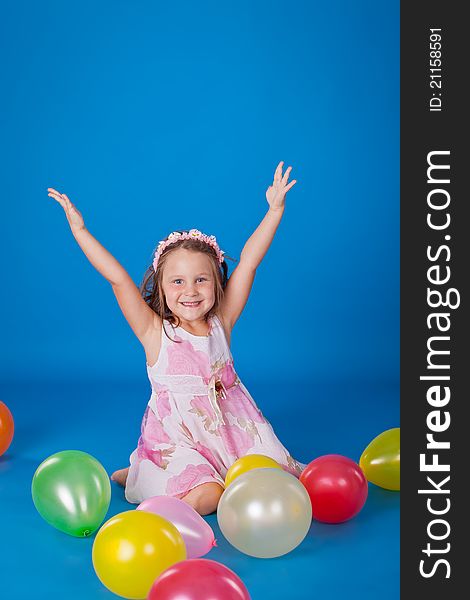 Happy child with colorful air ballons over blue