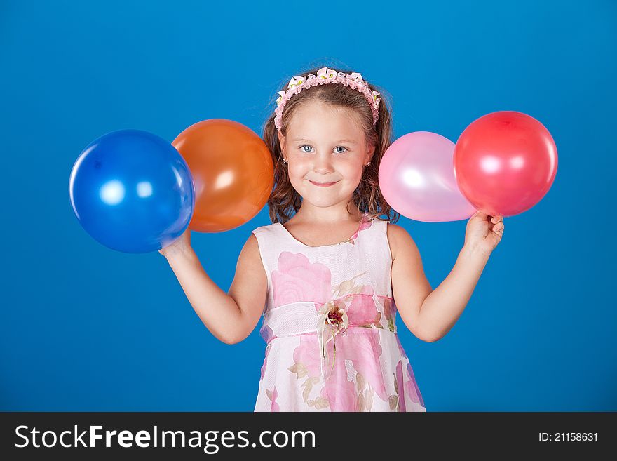 Happy child with colorful air ballons over blue