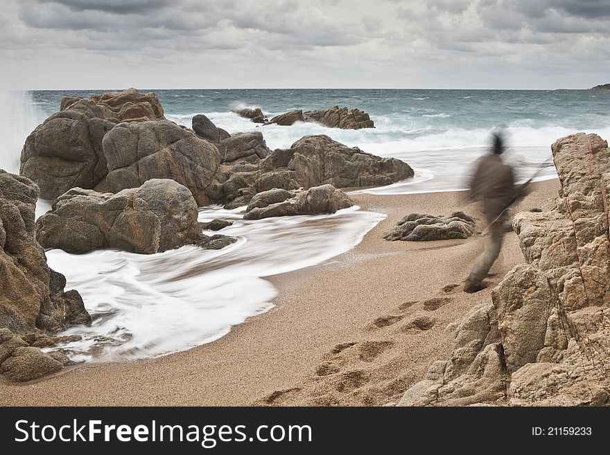 A lonely man is going to fish through the rough sea.