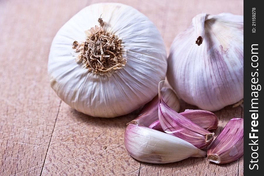 Garlic cloves placed on a wodden chopping board. Garlic cloves placed on a wodden chopping board