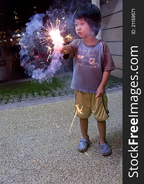 Engross Asian boy playing with fire crackers. Engross Asian boy playing with fire crackers