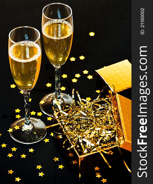 Two glasses of champagne with golden gift box